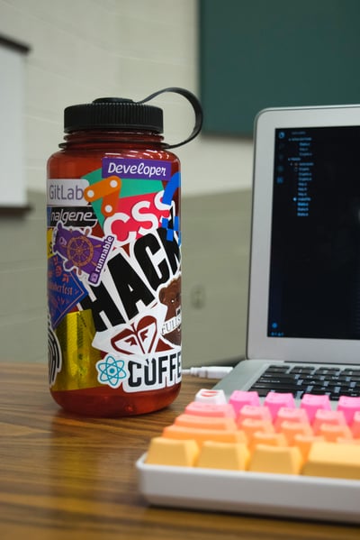 Water Bottle With Stickers and Laptop